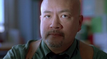 Movie still from “Paranoid Park” (2007), directed by Gus Van Sant – A man with a beard and mustache wearing a green shirt; Close Up shot, Low angle