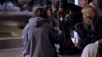 Movie still from “Paranoid Park” (2007), directed by Gus Van Sant – A man holding a skateboard while another man stands next to him; Wide shot, Low angle