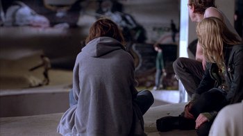 Movie still from “Paranoid Park” (2007), directed by Gus Van Sant – A woman sitting on the ground wearing a gray hoodie; Wide shot, High angle