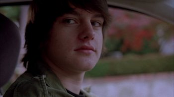 Movie still from “Paranoid Park” (2007), directed by Gus Van Sant – A person in a car with trees in the background; Close Up shot, Low angle