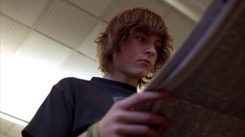 Movie still from “Paranoid Park” (2007), directed by Gus Van Sant – A young man is holding a newspaper in his hands; Close Up shot, Low angle