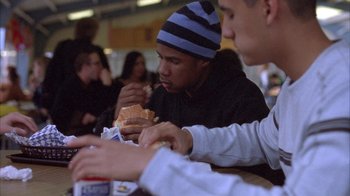 Movie still from “Paranoid Park” (2007), directed by Gus Van Sant – Two young men are eating a hot dog at a restaurant; Medium shot, Over the shoulder angle