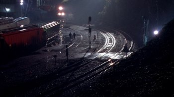 Movie still from “Paranoid Park” (2007), directed by Gus Van Sant – People are standing on a train track at night; Extreme Wide shot, High angle