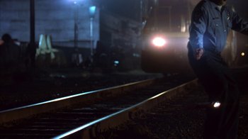 Movie still from “Paranoid Park” (2007), directed by Gus Van Sant – A person is standing on the train tracks at night; Wide shot, Low angle