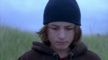 Movie still from “Paranoid Park” (2007), directed by Gus Van Sant – A young person wearing a blue hat and a brown jacket; Close Up shot, Low angle