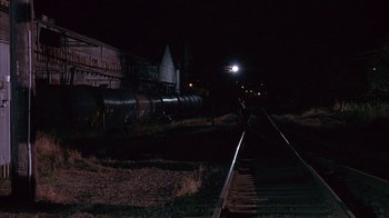 Movie still from “Paranoid Park” (2007), directed by Gus Van Sant – A train is on the railroad tracks at night; Extreme Wide shot, High angle