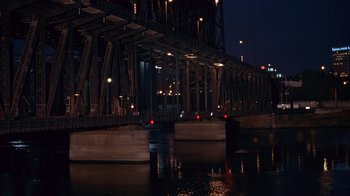 Movie still from “Paranoid Park” (2007), directed by Gus Van Sant – A view of a bridge at night from the water; Extreme Wide shot, High angle