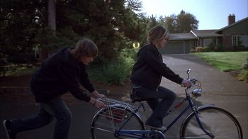 Movie still from “Paranoid Park” (2007), directed by Gus Van Sant – A man and a woman riding a bike down a street; Wide shot, Low angle