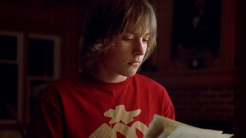 Movie still from “Paranoid Park” (2007), directed by Gus Van Sant – A boy is reading a book in the dark; Close Up shot, Low angle