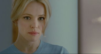 Movie still from “Passion” (2012), directed by Brian De Palma – A woman's face in front of a white wall; Close Up shot, Over the shoulder angle