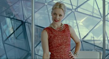 Movie still from “Passion” (2012), directed by Brian De Palma – A woman in a red dress posing for a picture; Medium shot, Low angle