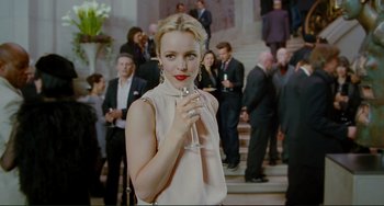 Movie still from “Passion” (2012), directed by Brian De Palma – A beautiful woman holding a glass of wine; Medium shot, Over the shoulder angle