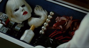 Movie still from “Passion” (2012), directed by Brian De Palma – A box with a wig , lipstick , and other accessories; Close Up shot, Overhead angle