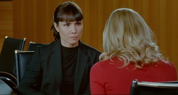 Movie still from “Passion” (2012), directed by Brian De Palma – A woman in a black jacket is talking to another woman in a red dress; Close Up shot, Over the shoulder angle