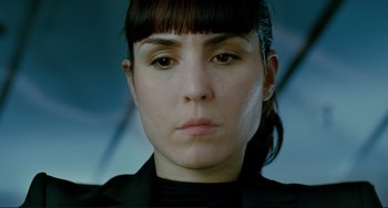 Movie still from “Passion” (2012), directed by Brian De Palma – A person wearing a suit and tie; Close Up shot, Low angle
