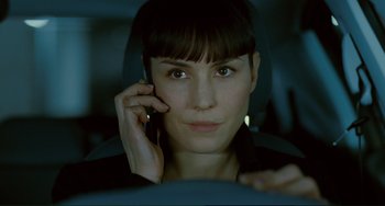 Movie still from “Passion” (2012), directed by Brian De Palma – A woman is talking on a cell phone while sitting in a car; Close Up shot, Over the shoulder angle