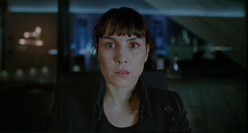 Movie still from “Passion” (2012), directed by Brian De Palma – A person wearing a black jacket; Close Up shot, Over the shoulder angle