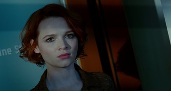 Movie still from “Passion” (2012), directed by Brian De Palma – A person with short red hair; Close Up shot, Low angle