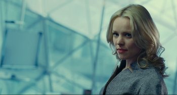 Movie still from “Passion” (2012), directed by Brian De Palma – A beautiful blond woman standing in front of a glass building; Close Up shot, Low angle