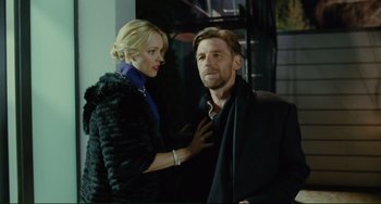 Movie still from “Passion” (2012), directed by Brian De Palma – A man and a woman standing next to each other; Medium shot, Over the shoulder angle