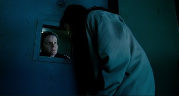 Movie still from “Passion” (2012), directed by Brian De Palma – A man and a woman looking at each other through a window; Medium shot, Over the shoulder angle