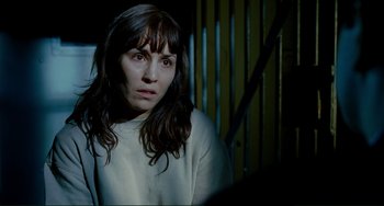 Movie still from “Passion” (2012), directed by Brian De Palma – A woman in a white shirt is looking at the camera; Close Up shot, Over the shoulder angle