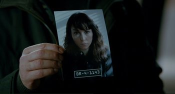 Movie still from “Passion” (2012), directed by Brian De Palma – A person holding a picture of a woman; Close Up shot, High angle