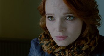 Movie still from “Passion” (2012), directed by Brian De Palma – A person wearing a jacket and a scarf; Close Up shot, Over the shoulder angle