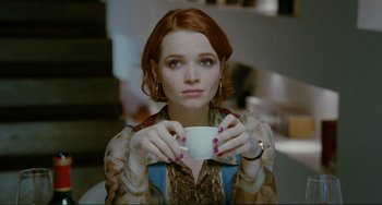 Movie still from “Passion” (2012), directed by Brian De Palma – A woman with red hair holding a cup of coffee; Close Up shot, High angle