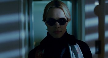 Movie still from “Passion” (2012), directed by Brian De Palma – A woman wearing sunglasses and a black jacket; Close Up shot, Low angle