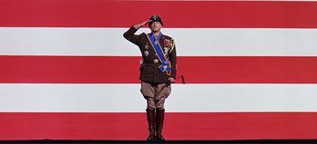 Movie still from “Patton” (1970), directed by Franklin J. Schaffner – A man saluting in front of an american flag; Wide shot, Low angle