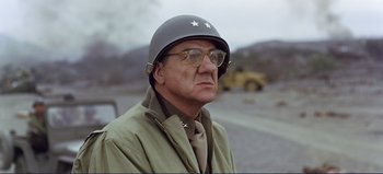 Movie still from “Patton” (1970), directed by Franklin J. Schaffner – An older man wearing a helmet with stars on it; Close Up shot, Over the shoulder angle