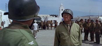 Movie still from “Patton” (1970), directed by Franklin J. Schaffner – A man wearing a helmet and a green jacket; Medium shot, Over the shoulder angle