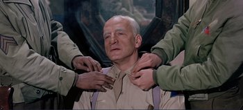 Movie still from “Patton” (1970), directed by Franklin J. Schaffner – A man is being fitted for a neck tie; Medium shot, Low angle