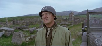 Movie still from “Patton” (1970), directed by Franklin J. Schaffner – An older man wearing a military uniform and a helmet; Medium shot, Low angle