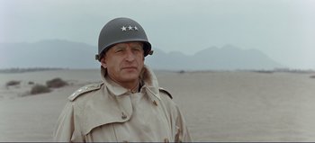 Movie still from “Patton” (1970), directed by Franklin J. Schaffner – A man in a military uniform wearing a helmet; Close Up shot, Low angle