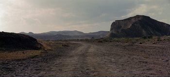 Movie still from “Patton” (1970), directed by Franklin J. Schaffner – A dirt road in the middle of a desert landscape; Extreme Wide shot, High angle