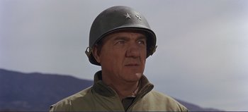 Movie still from “Patton” (1970), directed by Franklin J. Schaffner – An older man wearing an army helmet and jacket; Close Up shot, Low angle