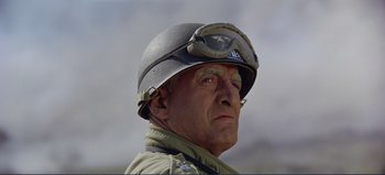 Movie still from “Patton” (1970), directed by Franklin J. Schaffner – An older man wearing a helmet and a uniform looking to his left; Close Up shot, Low angle