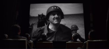 Movie still from “Patton” (1970), directed by Franklin J. Schaffner – An old photo of a man wearing a helmet; Medium shot, High angle