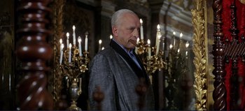 Movie still from “Patton” (1970), directed by Franklin J. Schaffner – An older man standing in front of a group of lit candles; Medium shot, Low angle