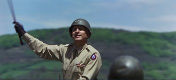 Movie still from “Patton” (1970), directed by Franklin J. Schaffner – A man in a military uniform wearing an army helmet; Medium shot, Low angle