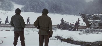Movie still from “Patton” (1970), directed by Franklin J. Schaffner – A man standing in the snow next to an atv; Wide shot, High angle
