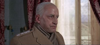Movie still from “Patton” (1970), directed by Franklin J. Schaffner – An older man wearing a coat and a scarf; Close Up shot, Low angle