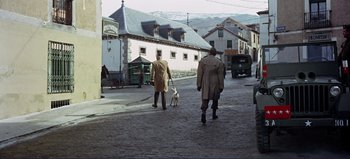 Movie still from “Patton” (1970), directed by Franklin J. Schaffner – Two men walking a dog down a street; Extreme Wide shot, High angle