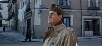 Movie still from “Patton” (1970), directed by Franklin J. Schaffner – A man in a military uniform is standing in front of a building; Medium shot, Low angle