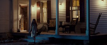 Movie still from “Paul” (2011), directed by Greg Mottola – A woman standing on the porch of a house at night; Wide shot, Low angle