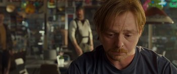 Movie still from “Paul” (2011), directed by Greg Mottola – A man with a beard is looking at the camera while another man stands in the background; Close Up shot, Over the shoulder angle