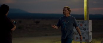 Movie still from “Paul” (2011), directed by Greg Mottola – A man standing in a field at night with his arms outstretched; Medium shot, Over the shoulder angle