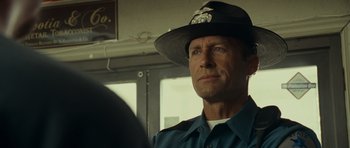 Movie still from “Paul” (2011), directed by Greg Mottola – A man in a police uniform looking at a mirror; Close Up shot, Over the shoulder angle